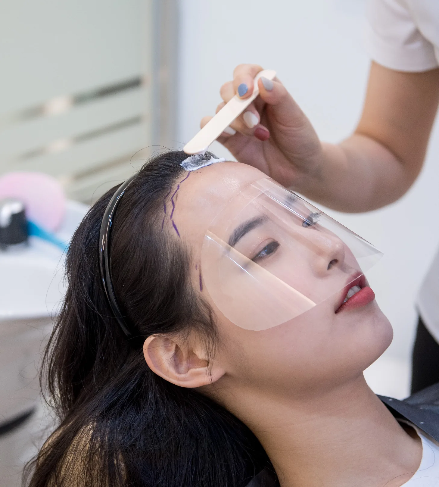 이마에 그린 디자인 라인을 따라 시술을 준비하는 장면